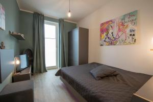 格洛韦Albert-INN-Glowe - barrierefrei & 3 Schlafzimmer & Coworking & Strandkorb-saisonal & Sauna im Haus & Fahrräder的一间卧室设有一张床、一台电视和一个窗口。