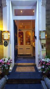 爱丁堡多尼亚同乐会酒店的台阶上鲜花盛开的建筑的前门