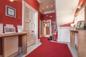 爱丁堡多尼亚同乐会酒店的走廊上设有红色的墙壁和红色的地毯