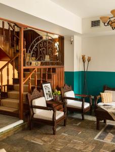 古迈尼萨季莫斯塞尼斯酒店的客厅配有椅子和楼梯间