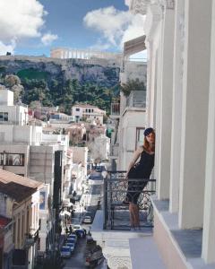 雅典埃姆帕里康雅典酒店的站在建筑物阳台上的妇女