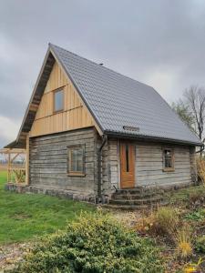 里加Rīga Mangalsala Cottage with sauna的一间黑色屋顶的小型木屋