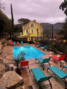 尼翁La Viste - SPA-JACUZZI - MASSAGE- SAUNA - 4 SAISONS - Piscine Chauffée Toute l'année - Heated POOL - 800m City Centre的一个带椅子的游泳池和一个背景房子