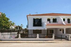 阿尔图拉Vila com piscina e jardim privado的前面有栅栏的白色房子