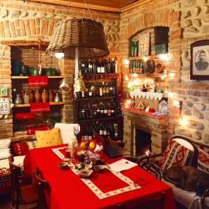 泰拉维Dzveli Galavani -Old Wall的一间设有红色桌子和壁炉的用餐室