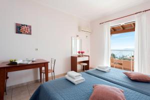 巴尔巴蒂Corfu Shell Apartments的一间卧室设有两张床、一张桌子和一个窗口。