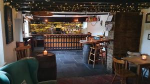 布里斯托Ring O Bells Hinton Blewett的餐厅设有酒吧、桌子和蜡烛