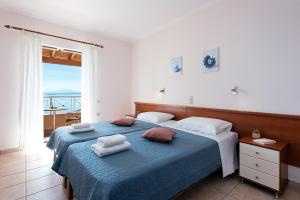 巴尔巴蒂Corfu Shell Apartments的一间卧室配有蓝色的床和毛巾