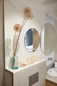 格丁尼亚Aparthotel Park - By The Sea的浴室设有两面镜子和花瓶