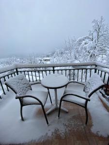 尼奥楚里翁Nefeles的雪覆盖在阳台上的桌椅