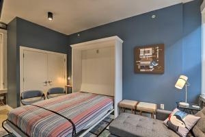 辛辛那提Sleek Studio Near Dtwn Dining and Entertainment的卧室拥有蓝色的墙壁,配有一张床和一张沙发