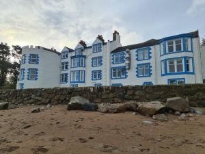 AuchencairnBalcary Bay Country House Hotel的海滩上一座蓝色和白色的大建筑