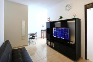 阿雷西费Holiday Apartment C Lanzarote的一间客厅,客厅内配有一台位于黑娱乐中心的电视