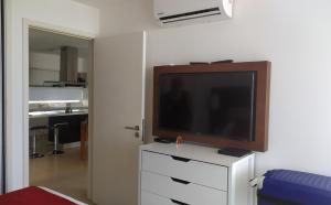 科洛尼亚-德尔萨克拉门托Dpto de 1 dormitorio, 402 Dos Orillas, Colonia的白色梳妆台上方的平面电视