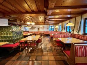 因泽尔施瓦岑贝格酒店的餐厅设有木制天花板、桌子和红色椅子