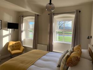 斯基普顿The Green at Burnsall的一间卧室配有一张床、一把椅子和窗户。