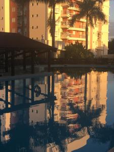 佩尼亚Apartamento em Home Club的棕榈树和建筑的海水游泳池