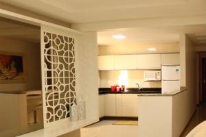 卡斯卡韦尔APTO completo para sua família!的厨房配有白色橱柜和图案墙