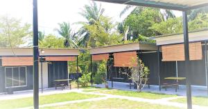 Kampong Bukit LintangHasina Resort @Sedili的前面有桌子和长凳的建筑