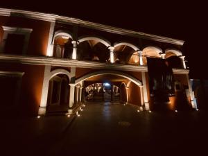 阿拉莫斯Hotel Real de los Alamos的一座空的建筑,晚上有拱门