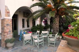 斯基罗斯岛Achilleion Hotel的一个带椅子和桌子的庭院和棕榈树