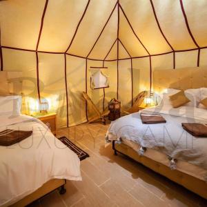 AdrouineSunset luxury camp的一间帐篷内带两张床的卧室