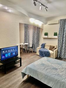 明斯克Apartment near Zybitskaya的客厅配有床和电视。