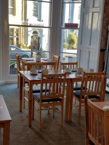 托基帕特里夏酒店的用餐室配有木桌、椅子和窗户