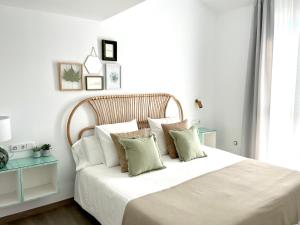 格拉纳达Apartamentos con encanto en el centro de Granada的卧室配有一张带白色床单和枕头的大床。