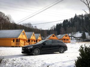 杜什尼基-兹德鲁伊Domki na Podgórzu的一辆停在房子前面的雪地上的黑色汽车