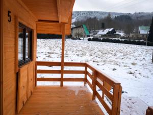 杜什尼基-兹德鲁伊Domki na Podgórzu的小屋的门廊,地面上有雪