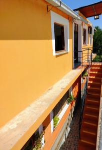 卡法亚特Hopedaje Felisa的黄色建筑,有楼梯和盆栽植物
