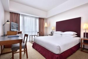 吉隆坡吉隆坡国会大厦酒店的酒店客房设有一张大床和一张书桌。