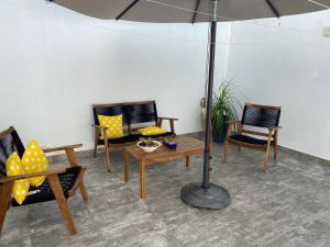 坎昆Closetoairport的庭院配有椅子和桌子及遮阳伞