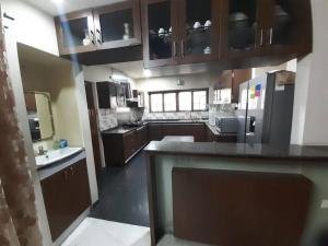 海得拉巴Jubilee Hills Duplex Villa For Family Stay的一个带木制橱柜和台面的大厨房