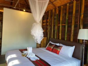 Ban Huai TiSay Love Baan Sapan บอกฮักบ้านสะปัน的一间卧室配有带白色床单和红色枕头的床。
