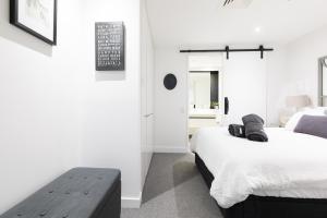 墨尔本The Port Melbourne Experience的一间卧室配有两张床,内设长凳