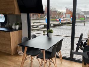 厄伊特海斯特Modern houseboat with roof terrace, on Uitgeestermeer的厨房配有桌椅,享有水景