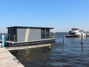 厄伊特海斯特Modern houseboat with air conditioning located in marina的船坞旁的小船