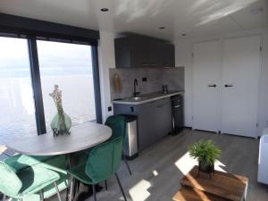厄伊特海斯特Modern houseboat with air conditioning located in marina的带桌椅的厨房和带窗户的厨房