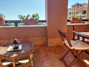 卡内拉岛Apartamento Playa Verde的阳台配有桌椅和桌子。