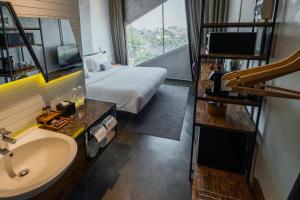 万隆Janevalla Bandung的酒店客房设有床、水槽和窗户。