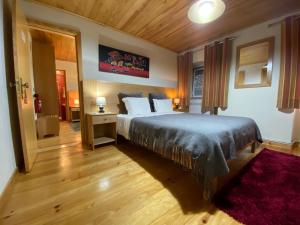 洛里加欧文森特旅馆的一间卧室配有一张大床和红色地毯。