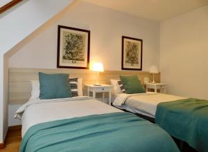 萨达Rías Altas Home Sada的一间卧室配有两张带绿色和白色床单的床