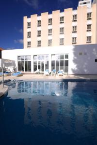 圣地亚哥-杜卡森多姆努诺酒店的大楼前设有游泳池的酒店