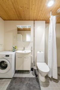赫尔辛基SleepWell Apartment Rio with private sauna and parking的浴室配有卫生间、盥洗盆和洗衣机。