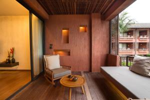 波普托Hansar Samui Resort & Spa - SHA Extra Plus的一间卧室配有一张床、一把椅子和一张桌子