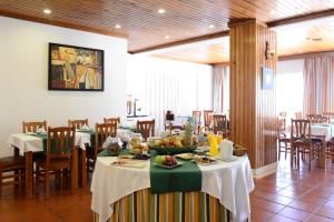 圣地亚哥-杜卡森多姆努诺酒店的用餐室配有桌椅和食物