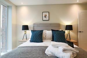 韦林花园城Portfolio Apartments - Welwyn Town Centre的一间卧室配有一张带蓝色枕头的大床