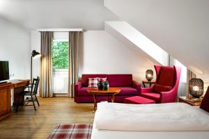慕尼黑Hotel Prinzregent München Messe的客厅配有红色的沙发和桌子